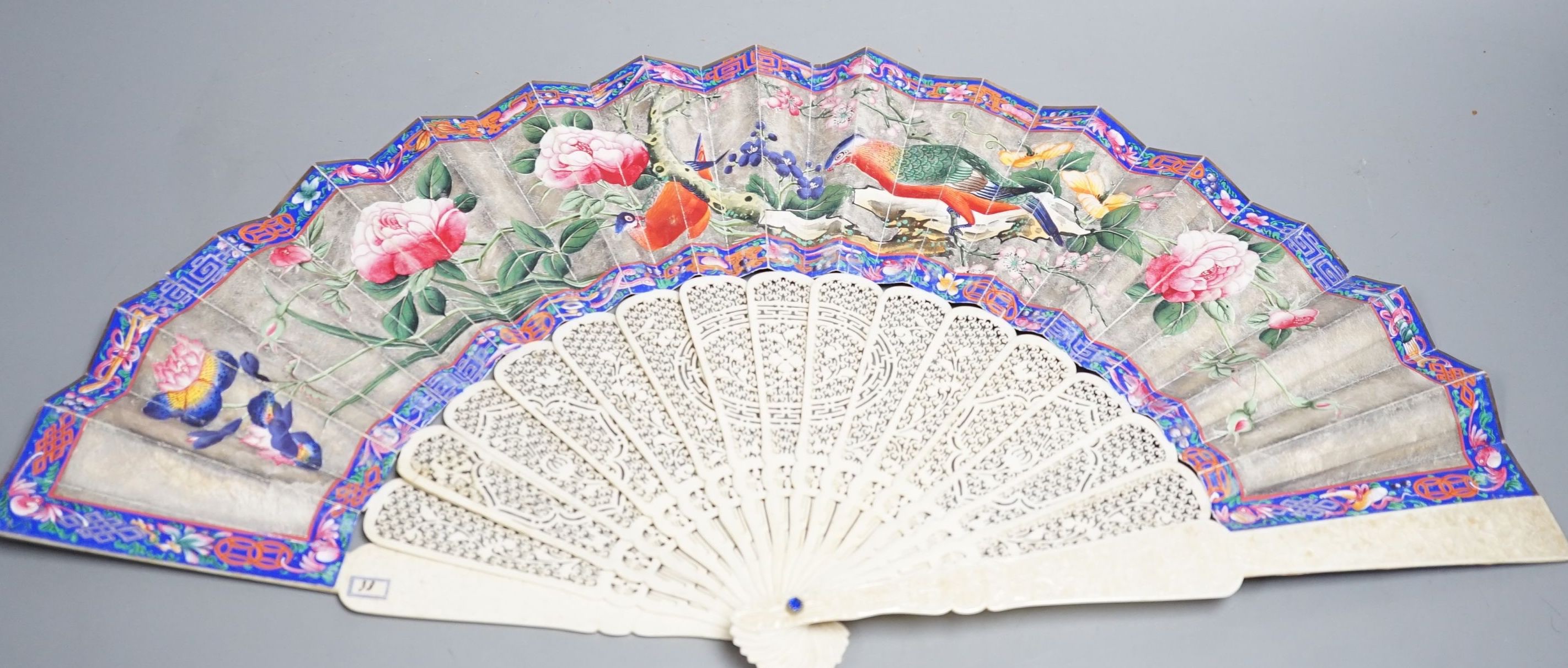 A 19th century Chinese export pierced ivory and painted paper leaf fan. 28cm long